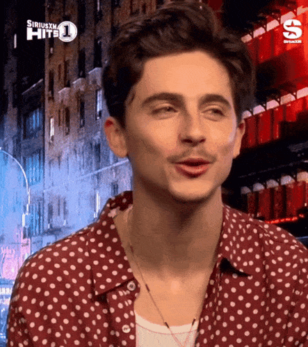 a man wearing a red polka dot shirt with siriusxm hits 1 on the bottom