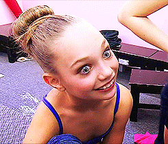 a young girl with a bun on her head is smiling