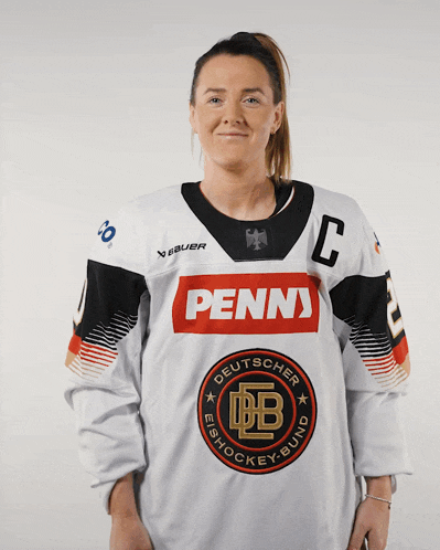 a woman is wearing a penns jersey and smiling