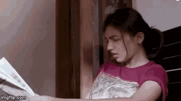 a woman is sitting on a bed reading a book .