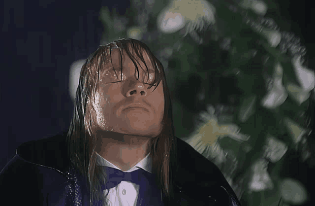 a man in a tuxedo is standing in the rain