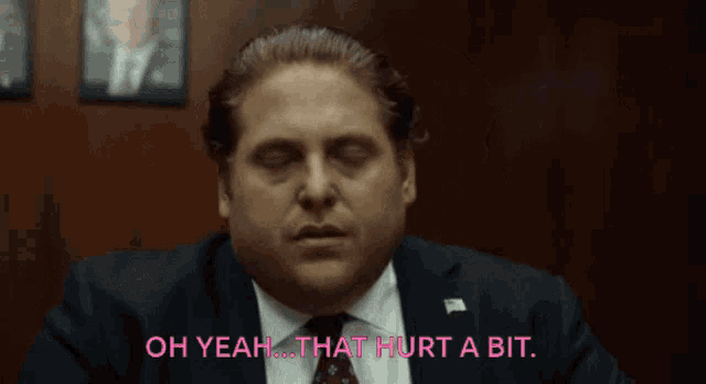 a man in a suit and tie is saying " oh yeah that hurt a bit "