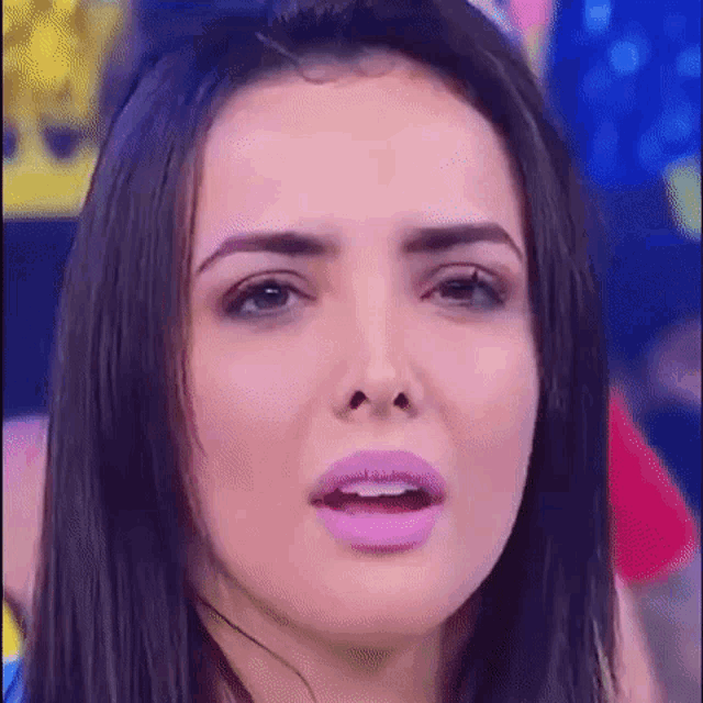 a close up of a woman 's face with purple lipstick on .
