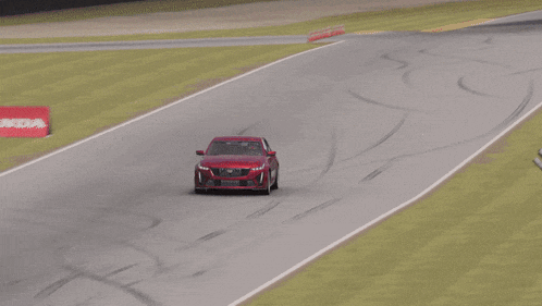 a red car is driving on a race track with a sign that says no