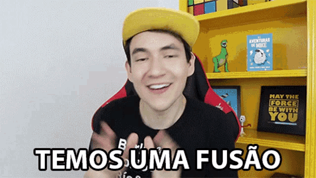 a man wearing a yellow hat says " temos uma fusão "