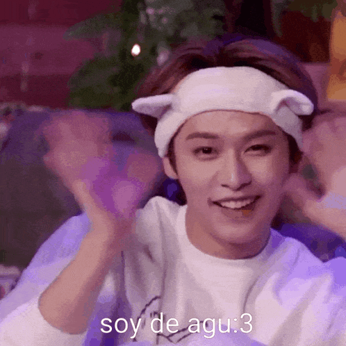 a young man wearing a headband with cat ears and the words soy de agu : 3