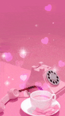 a pink phone sits on a saucer next to a cup of tea and a creative infinity sign