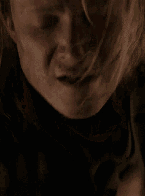 a close up of a woman 's face with her eyes closed and her mouth open
