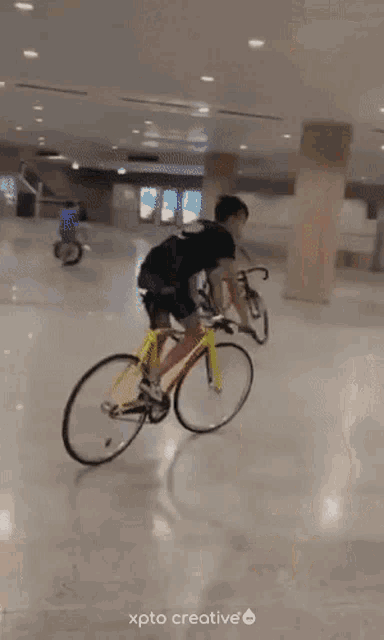 a man is riding a yellow bicycle with xpto creative written on the bottom right