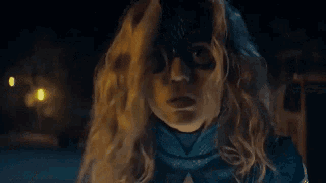 a close up of a woman wearing a mask and a costume .