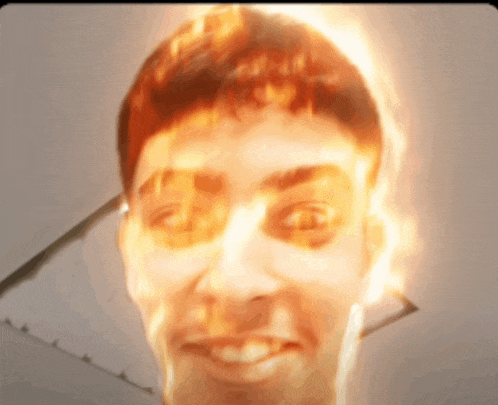 a close up of a man 's face with fire coming out of it