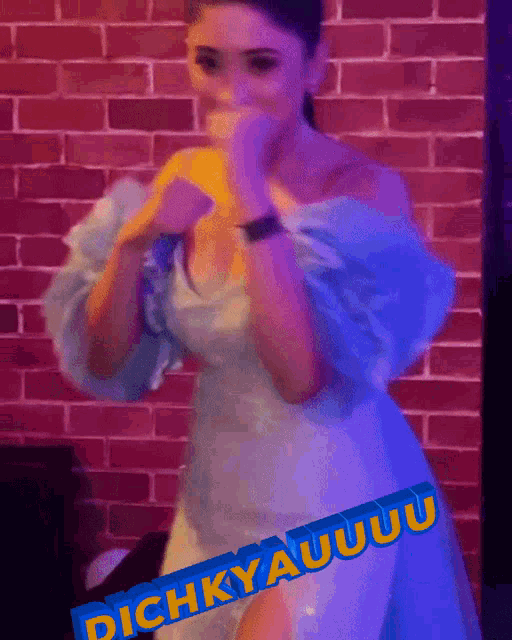 a woman in a white dress is standing in front of a brick wall and a sign that says " dichkyauuuu "