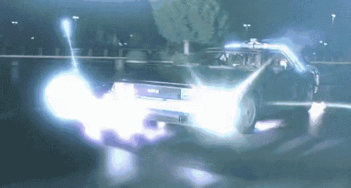 a back to the future car is driving down a dark street