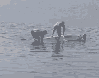 a man is paddling a boat in the water while another man watches