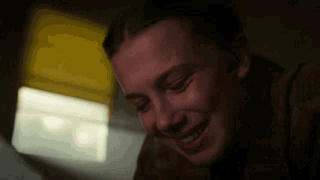 a close up of a woman laughing with her eyes closed .