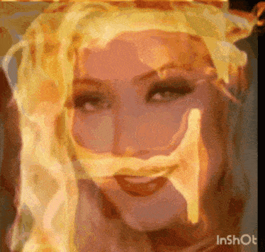 a close up of a woman 's face with flames coming out of her mouth and hair .