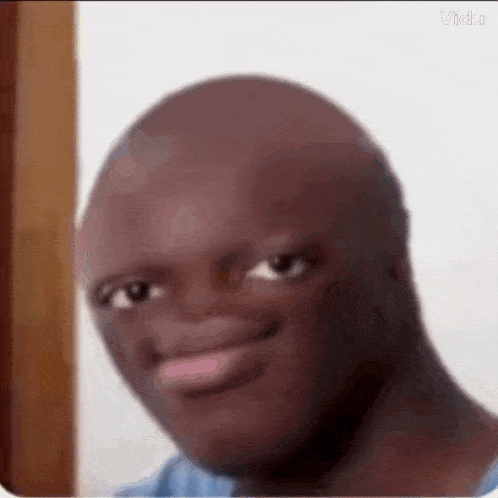 a close up of a bald man 's face with a big smile on his face .