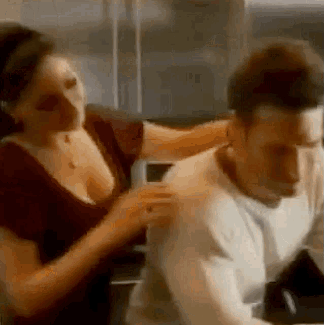 a woman is putting her arm around a man 's shoulder in a blurry photo .