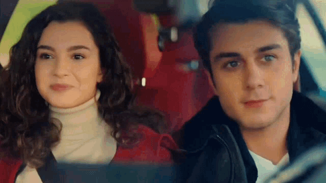 a man and a woman are sitting in a car .