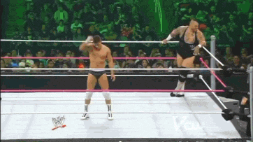 two men are wrestling in a ring with a sign that says wwe on it