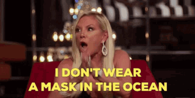 a woman is sitting on a red couch and says i don t wear a mask in the ocean .