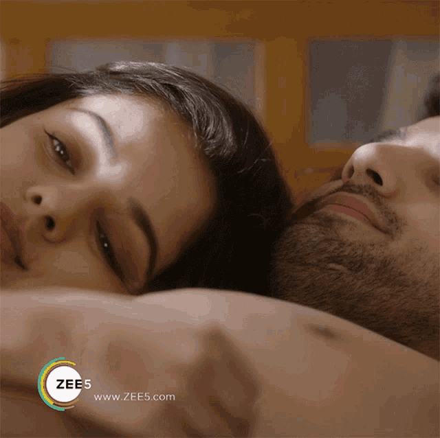 a man and a woman laying on a bed with the words zee5 www.zees.com