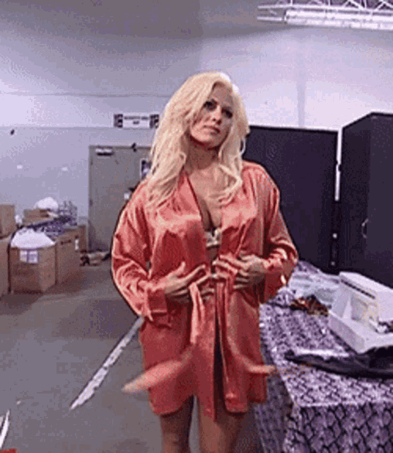 a woman in a red robe is standing in a warehouse .