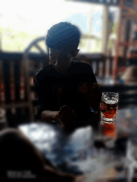 a man sits at a table with a glass of beer on it