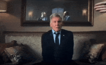 a man in a suit and tie sitting on a couch