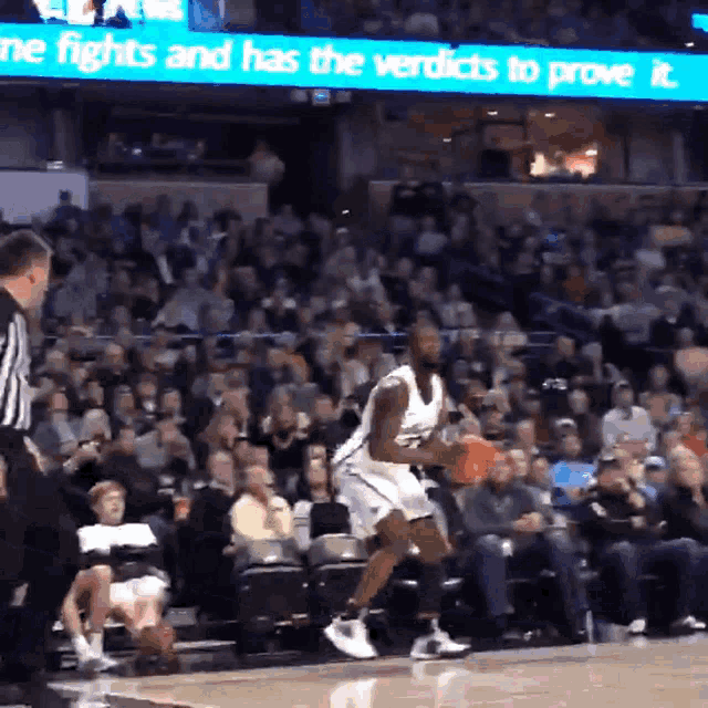 a basketball player dribbles the ball in front of a banner that says " me fights and has the verdicts to prove it "