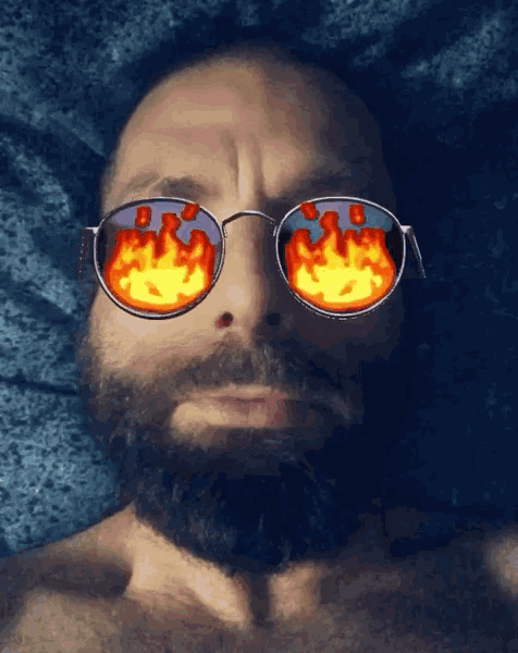 a man with a beard is wearing sunglasses with flames on them
