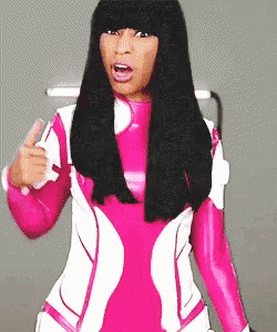 a woman in a pink and white outfit is pointing at something