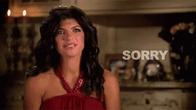a woman in a red dress is standing in front of a counter and says sorry .