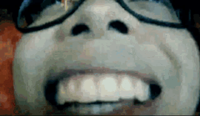 a close up of a person 's face with glasses on