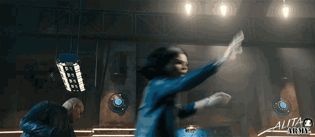 a movie poster for alita army 2 shows a woman in a blue jacket throwing a sword