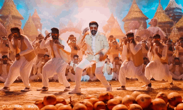 a man in a white shirt is dancing in front of a crowd with a watermark that says nandamurifars