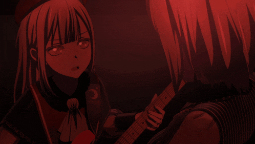 a girl holding a guitar looks at another girl in a red light