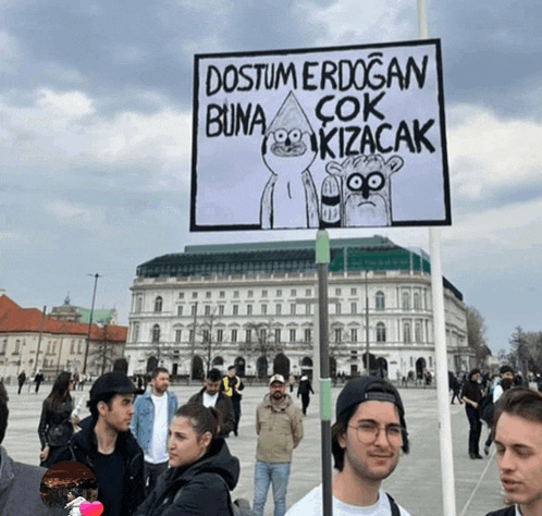 a man holding a sign that says " dostum erdogan buna çok kizacak "