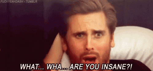 a man with a beard is laying on a bed and making a funny face while talking to someone .