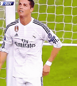a soccer player in a fly emirates jersey stands in front of a goal