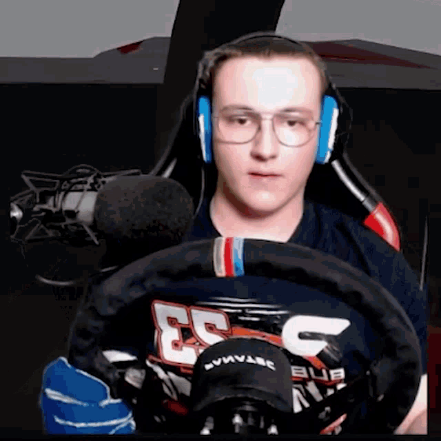 a man wearing headphones and a steering wheel that says esc on it