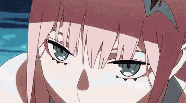 a close up of a pink haired anime girl with blue eyes looking at the camera .