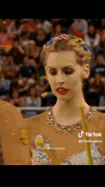 a woman with flowers in her hair is standing in front of a crowd