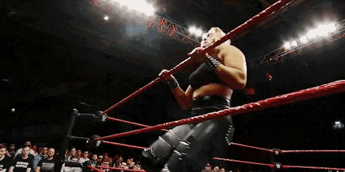 a wrestler is hanging upside down in a ring