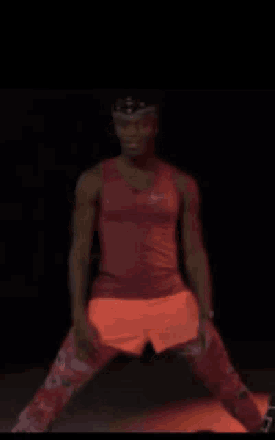 a group of people are standing on yoga mats in a dark room .
