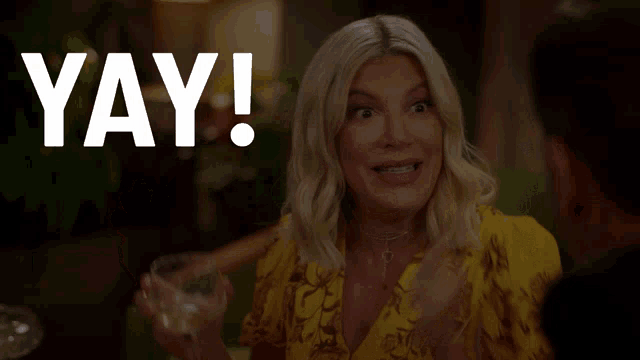 a woman in a yellow dress holds a glass of wine in front of the word yay