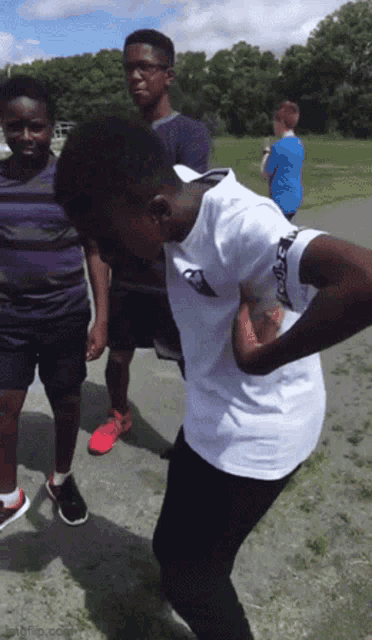 a boy wearing a white shirt with the word reebok on the sleeve