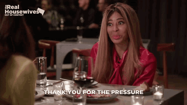 a woman sitting at a table with the words thank you for the pressure