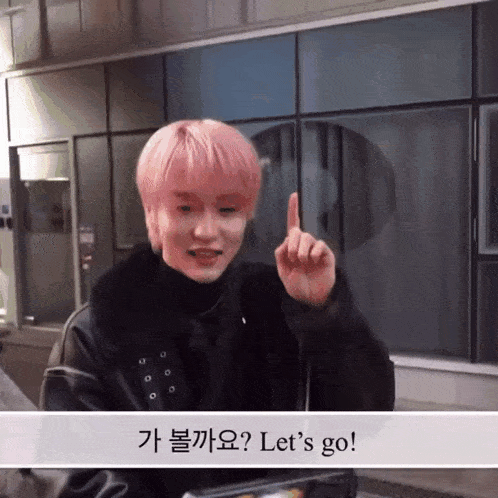 a young man with pink hair says let 's go with his finger up