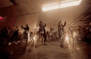 a group of people are dancing in a dark room in a parking garage .
